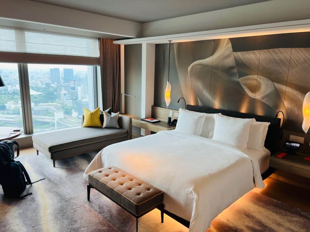 Bed and sofa in hotel room with city view