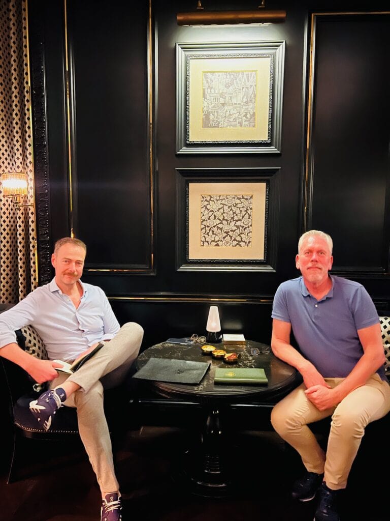 Two people relax in the chic Firefly Bar at Sindhorn Kempinski Bangkok.