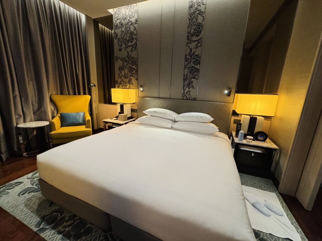 Comfortable bedroom with large king bed and warm lighting in Sindhorn Kempinski Bangkok.