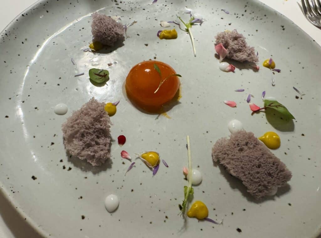 Sous-vide cooked duck egg with sponge cake and colorful garnishes at R-Haan.