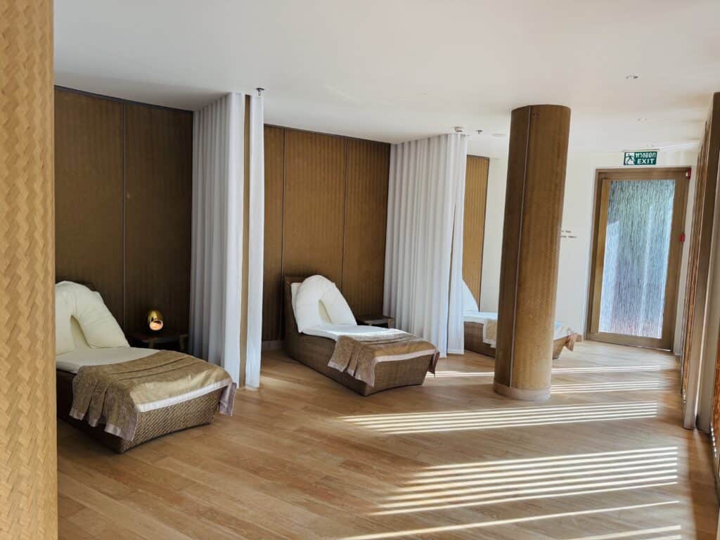 Relaxation area with loungers and warm wooden finishes in the Spa at Phulay Bay.