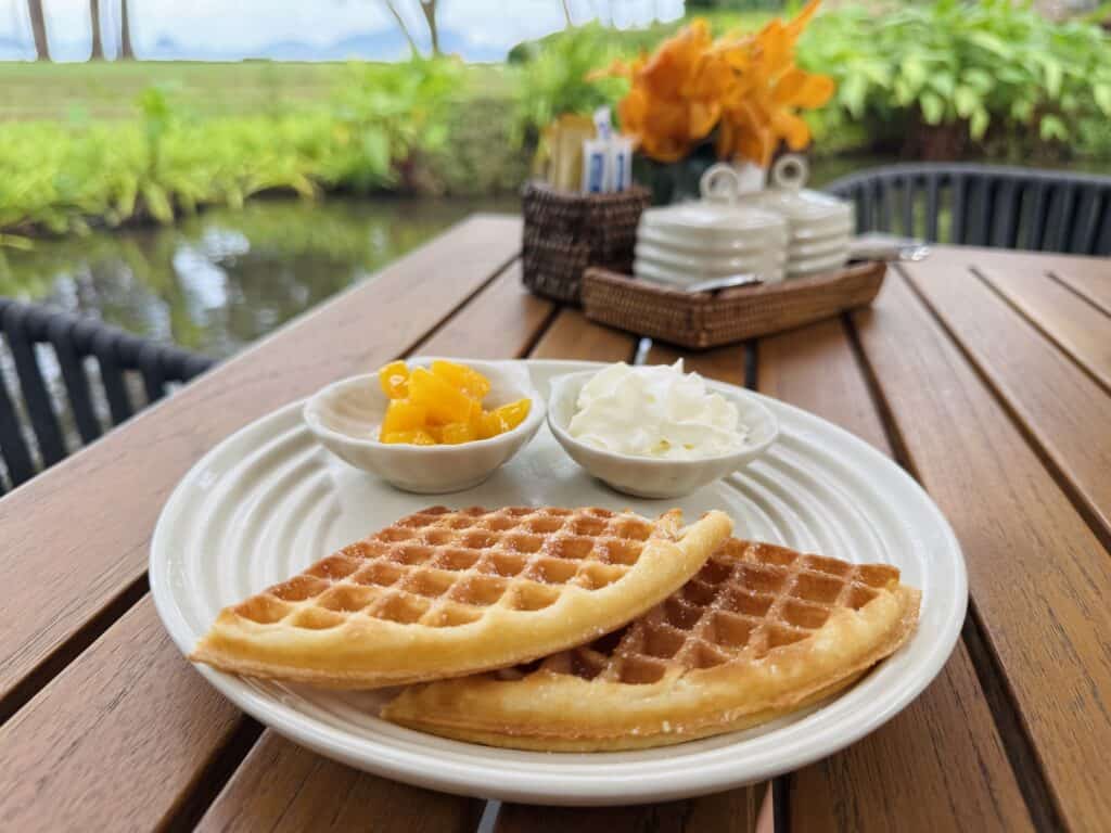 Fresh waffles served with mango and cream on an outdoor terrace at Phulay Bay, a Ritz-Carlton Reserve.