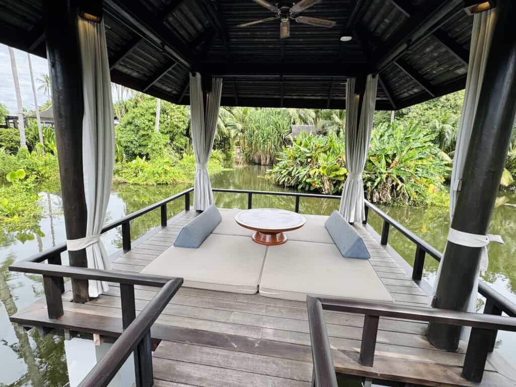 Covered lagoon sala with daybed at Anantara Mai Khao Phuket, ideal for relaxing over the water.