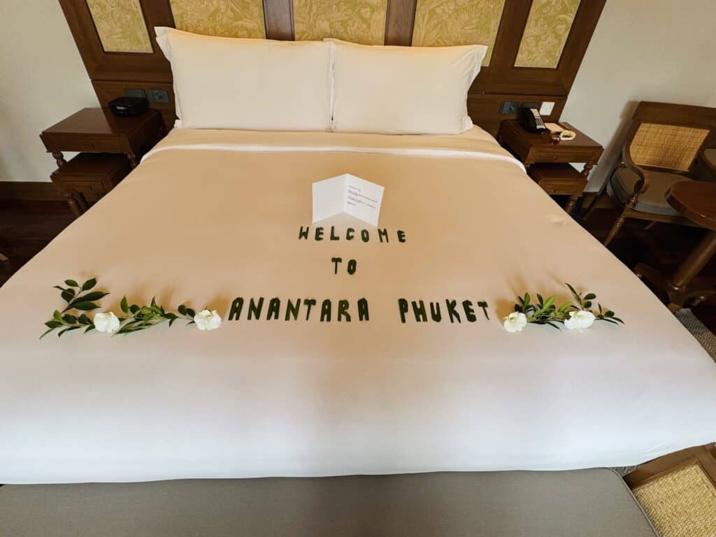 Welcome decoration on the bed in the villa at Anantara Mai Khao Phuket with flowers and a personalized card